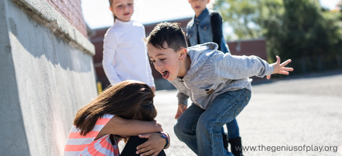 elementary school aged boy bullying young girl in playground 