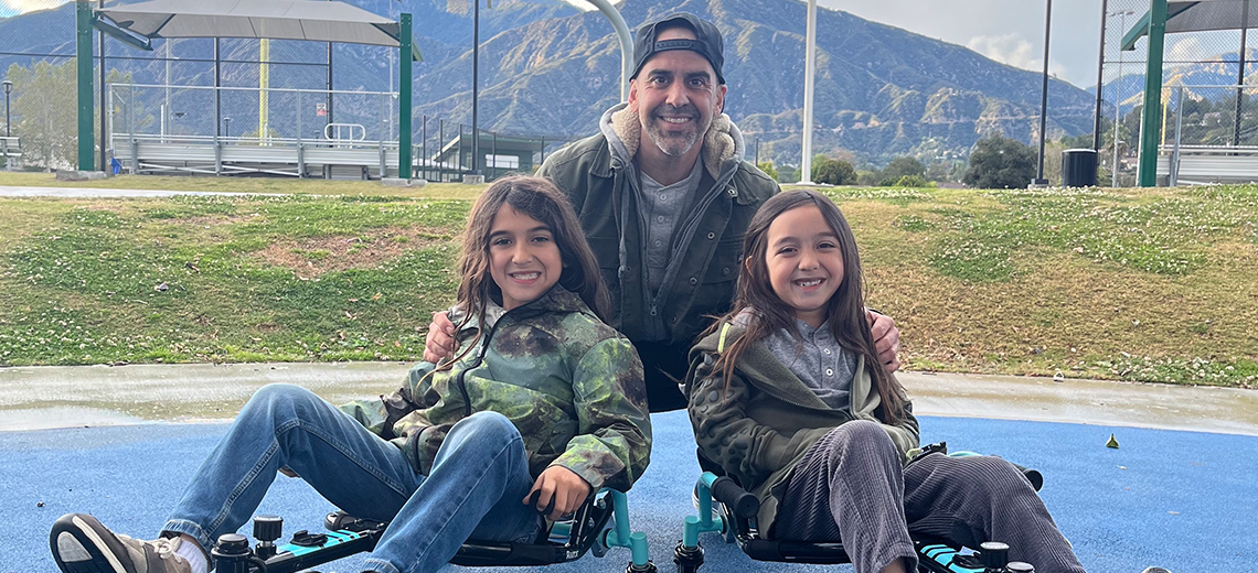 Dad and tween aged kids smiling on go carts