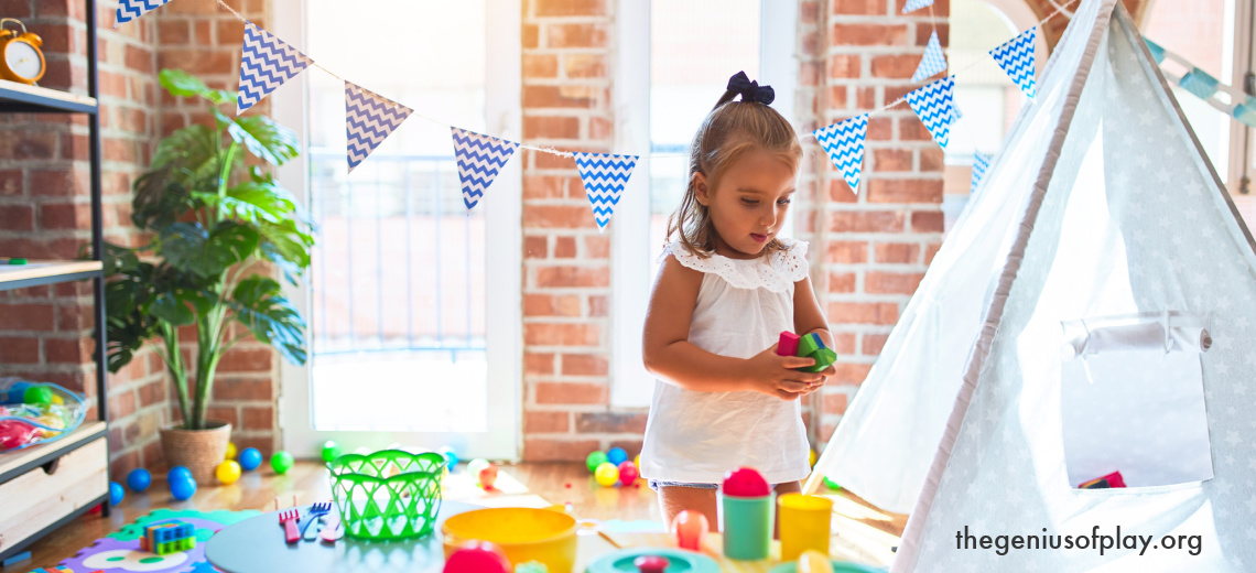 young girl enjoying playing to learn surrounded by multiple different toys in her room at home