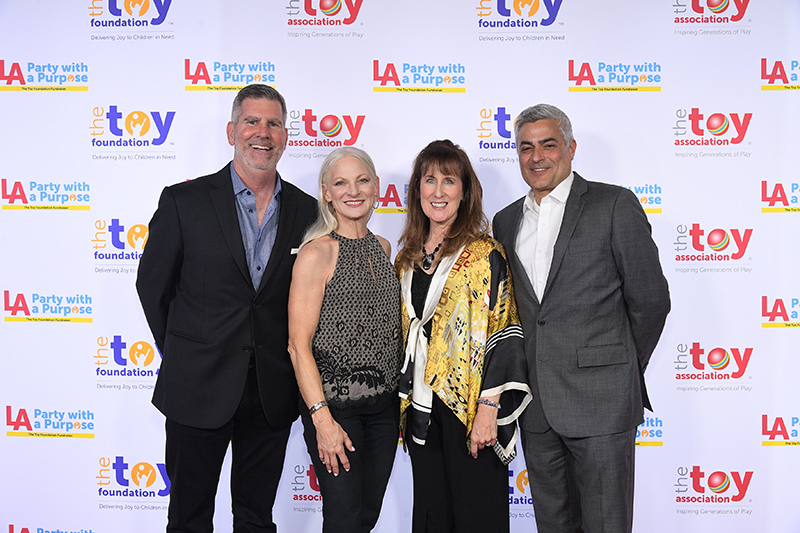 toy asociation members in front of step and repeat at party with a purpose